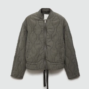 Grå quiltad jacka med dragkedja - Snygg grå quiltad jacka med dragkedja framtill och rund hals. Jackan har långa ärmar och praktiska fickor på sidorna. Den är från mango super populär och helt slutsåld på deras hemsida, nypris 900kr.