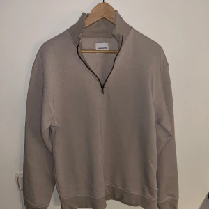 Beige half zip från Jack & Jones - Säljer en stilren beige half zip från Jack & Jones. Tröjan har fått noppor så därför säljer jag för lågt pris.
