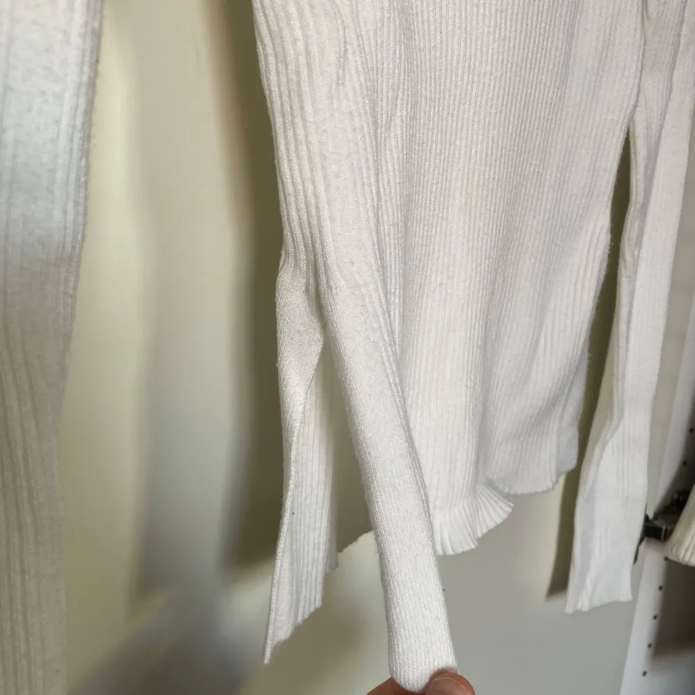 Superfin tunt stickad topp från BikBok med urringning och slits på sidan av tröjan, använd men fortfarande i fint skick . Neuletakit & Villapaidat.