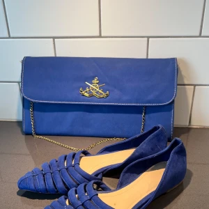 Blå kuvertväska och skorna är från Zara  - Snygg blå kuvertväska sammet med guldfärgad kedja och logodetalj på framsidan. Väskan har en stilren design med en praktisk kedja för att bära över axeln. Perfekt för att ge en färgklick till din outfit. Skorna från Zara 38 storlek . Kombinerade de två material och färgen passade mycket fint. Skorna aldrig använd . 