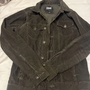 Brun manchesterjacka från Urban Classics - Säljer en snygg brun manchesterjacka från Urban Classics. Jackan har knappar framtill och två bröstfickor med lock. Perfekt för en cool och avslappnad stil.