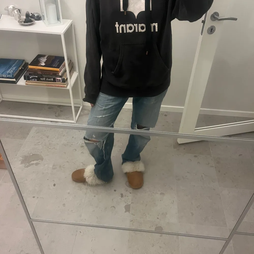 Säljer en svart hoodie från Isabel Marant med en stor vit logotyp på framsidan. Hoodien har en rymlig passform och en praktisk magficka. Perfekt för en avslappnad stil.. Neuletakit & Villapaidat.