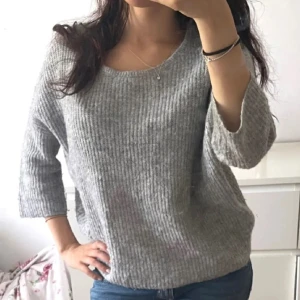 Grå stickad tröja - Mysig grå stickad tröja med trekvartsärm och en avslappnad passform. 