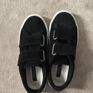 Skor från sneaky Steve  - Snygga svarta sneakers från Sneaky Steve med praktiska kardborreband och vit sula. Använda cirka 5 gånger och inga stora defekter. Storlek 37 men passar nog lite större då jag har själv har 38 egentligen. Perfekta för en stilren och bekväm look😉
