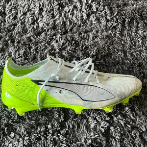 Puma ultra elite vit/gröna - Ett par fotbollsskor som jag fick av Jalal Abdullai i Elfsborg. Skorna är i bra skick men man kan se lite märken på skorna som visar att dem är använda.