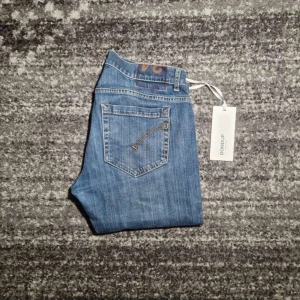 Dondup jeans - Snygga blå jeans från Dondup med en klassisk femficksdesign. De har en dragkedja och knapp framtill. Perfekta för en stilren look.
