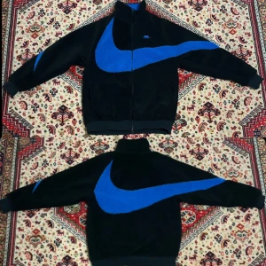 nike big swoosh reversible boa jacket - Köpt från StockX. Använd en gång. Har en. Liten fläck på armen. Har fickor på magen med dragkedjor. Storlek L. Kan passa M också