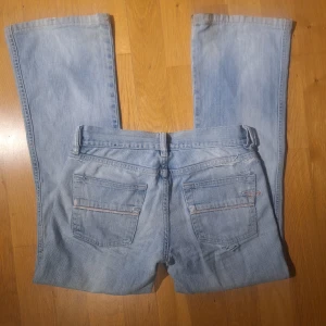 Ljusblå bootcut jeans från Diesel - Jättefina bootcut diesel jeans i stl 25 vilket motsvarar xs ungefär. Innebenslängd: 68 cm Midjemått tvärs över: 34cm Defekter syns på två sista bilderna, går att sy det till nytt och defekter vid benen är inget synligt när man har på sig dem! Skriv om du har frågor!