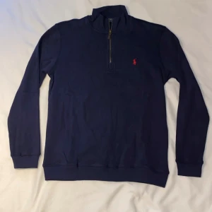 Ralph Lauren Quarter Zip - Säljer en riktigt fin och klassisk quarter zip från Ralph Lauren, perfekt för både vardag och lite mer avslappnade tillfällen. Den är både stilren och bekväm, och passar bra till både jeans och chinos.  Color: Navy                                                        Cond: 10/10 Size: M  Ett utmärkt tillskott till garderoben!