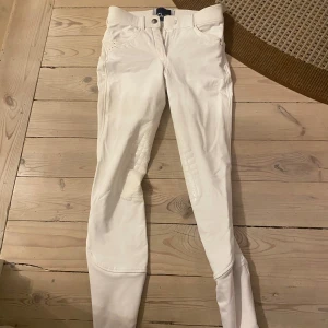 Vita ridbyxor från CRW - Snygga vita ridbyxor från Cavalleria Toscana med  stilrena detaljer. Byxorna har en tight passform och är perfekta för ridning. De är dekorerade med små stenar på baksidan och har praktiska fickor.