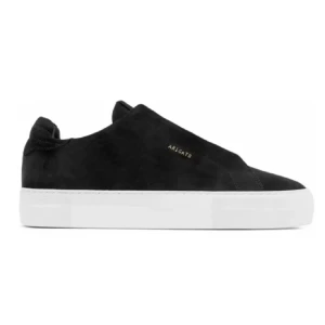 Svarta sneakers från Axel Arigato - Stilrena svarta sneakers i mocka från Axel Arigato med en vit sula. Skorna har en minimalistisk design utan snörning och en diskret logotyp i guld på sidan.