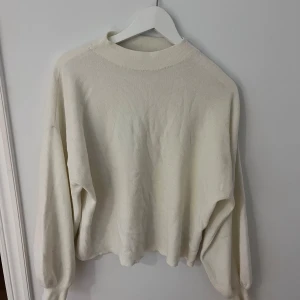 Vit tröja från Vero Moda - Säljer en stilren vit tröja från Vero Moda. Tröjan har en ribbad struktur och långa ärmar, perfekt för en avslappnad look. Den är i storlek M och passar bra till både jeans och kjol.  