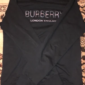Svart tröja från Burberry - Snygg svart tröja från Burberry med texten 'London England' på bröstet. Perfekt för en stilren look.