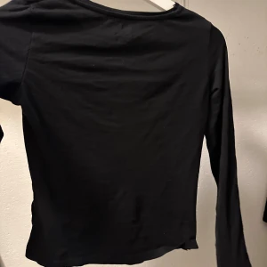 Svart långärmad topp - Säljer en stilren svart långärmad topp. Perfekt för lager-på-lager eller som den är. Enkel design med rund halsringning.