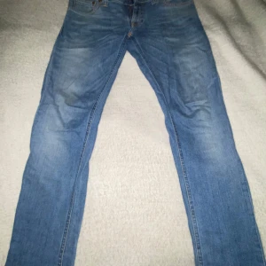 Blå jeans från Nudie - Tjena, säljer ett par riktig schyssta nudie jeans. Med blått mönster där bak till skillnad från den klassiska oranga. Passformen är slim och har väldigt lite tecken på användning. Just denna modell från nudie görs ej längre. OBS priset är ej hugget i sten