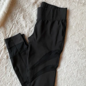 Svarta leggings med hög midja - Snygga svarta leggings med hög midja och stilrena detaljer. Perfekta för både träning och vardag. De har en tight passform som framhäver figuren och ger bra stöd.
