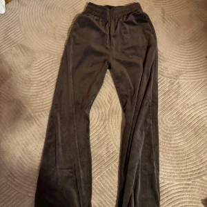 Tre par byxor i olika färger - Säljer tre par byxor i olika färger och material. Första paret är bruna med en loose passform och elastisk midja. Andra paret är beige mjukisbyxor med snörning och fickor. Tredje paret är svarta ribbade byxor med en tight passform.