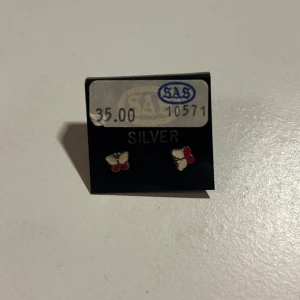 Söta fjärilsörhängen i silver - Charmiga små örhängen i form av fjärilar.🦋 De är tillverkade i silver och har detaljer i rött och vitt. Perfekta för att lägga till en söt detalj till din outfit. Aldrig använda. 