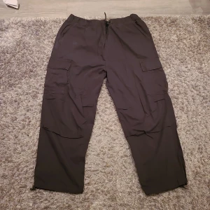 Svarta cargobyxor från Zara - Avslappnad passform, tunnt material som är perfekt till vår/sommar, flera fickor för funktionalitet och stil.