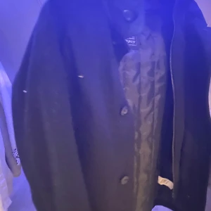 Svart jacka från Hampton Republic - Säljer en stilren svart jacka från Hampton Republic. Jackan har knappar och en quiltad insida som ger extra värme. Perfekt för kyligare dagar med sin klassiska design.