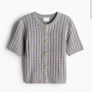 Stickad kofta  - Stickad kofta med guldknappar från hm som är slutsåld. Kvar i original förpackningen med prislapp kvar då den inte kommit till användning.