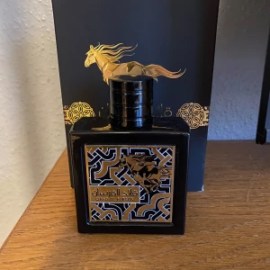Lataffa Qaed Al Fursan - Elegant parfym i en svart fyrkantig flaska med gyllene detaljer och ett hästmotiv. Endast testad. Skriv för funderingar 