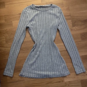 Grå ribbad tröja från Shein - Säljer en stilren grå ribbad tröja från Shein. Tröjan har en figurnära passform och långa ärmar, perfekt för en avslappnad look. Den är tillverkad i ett mjukt material som känns skönt mot huden. Storleken är S. 