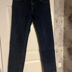 Mörkblå jeansbyxor - Snygga mörkblå jeansbyxor med klassisk design. De har en rak passform och är perfekta för en avslappnad stil. Byxorna har en dragkedja och knappar framtill.