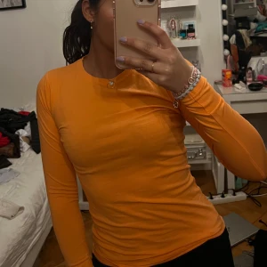 Orange långärmad tröja - Säljer en snygg orange långärmad tröja i bomull. Perfekt för höst och vår med sin enkla design och bekväma passform. Tröjan har en rund halsringning och är i en härlig, livfull färg. Passar bra till både jeans och kjol. Storlek 158-164 men passar xxs-s. Använd vid ett tillfälle!
