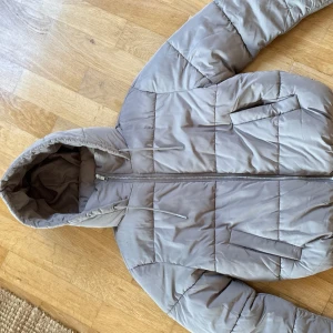 Beige pufferjacka med huva - beige/grå  jacka använd fåtal gånger ordinarie pris 699kr