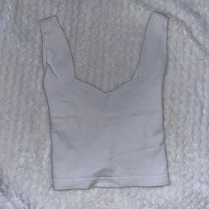Vitt linne  - Säljer ett vitt linne med djup v-ringning. Skulle gissa att storleken är S🤍