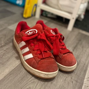 Röda Adidas Campus 00 - Jättesköna skor, man får med ett par vita snören och röda smala snören, pris kan diskuteras vid seriös köpare😊Inte använt supermycket men rengörs innan köp🥰Nypris:1449kr 