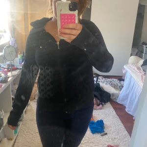 Svart hoodie med dragkedja - Säljer en svart hoodie med dragkedja och huva. Perfekt för en avslappnad stil. Den har långa ärmar och en bekväm passform. Perfekt för kyligare dagar. Sitter som en s enligt mig.