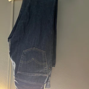Levi's 501 jeans - Klassiska Levi's 501 jeans i mörkblå denim. De har en rak passform och är tillverkade i bomull. Perfekta för en tidlös stil med fem fickor och knappgylf. Hör av dig vid minsta fundering! Pris ej hugget i sten, väljer du att köpa fler artiklar från min sida kan jag ge ett ett billiga pris👍 finns även på Vinted!. Fraktar inom 48 h. W30 l30