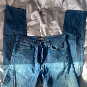 Blå jeans från Lee - Snygga blå jeans från Lee med klassisk femficksdesign och knappgylf. Perfekta för en avslappnad stil. Tillverkade i slitstarkt denim.