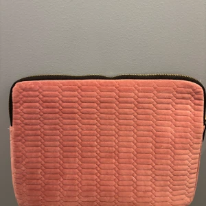 Datorfodral - Snygg rosa datorväska med quiltat mönster och dragkedja. Perfekt för att skydda din laptop med stil. Den har en mjuk yta och en praktisk dragkedja i guld för enkel öppning och stängning.