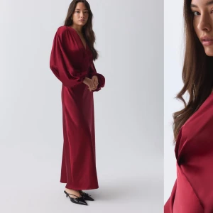 Vinröd långklänning med v-ringning - Elegant vinröd långklänning i satin med djup v-ringning och långa ärmar. Perfekt för en festlig kväll med sin flytande siluett och lyxiga känsla. Endast använt en gång. Nypris 699,95kr