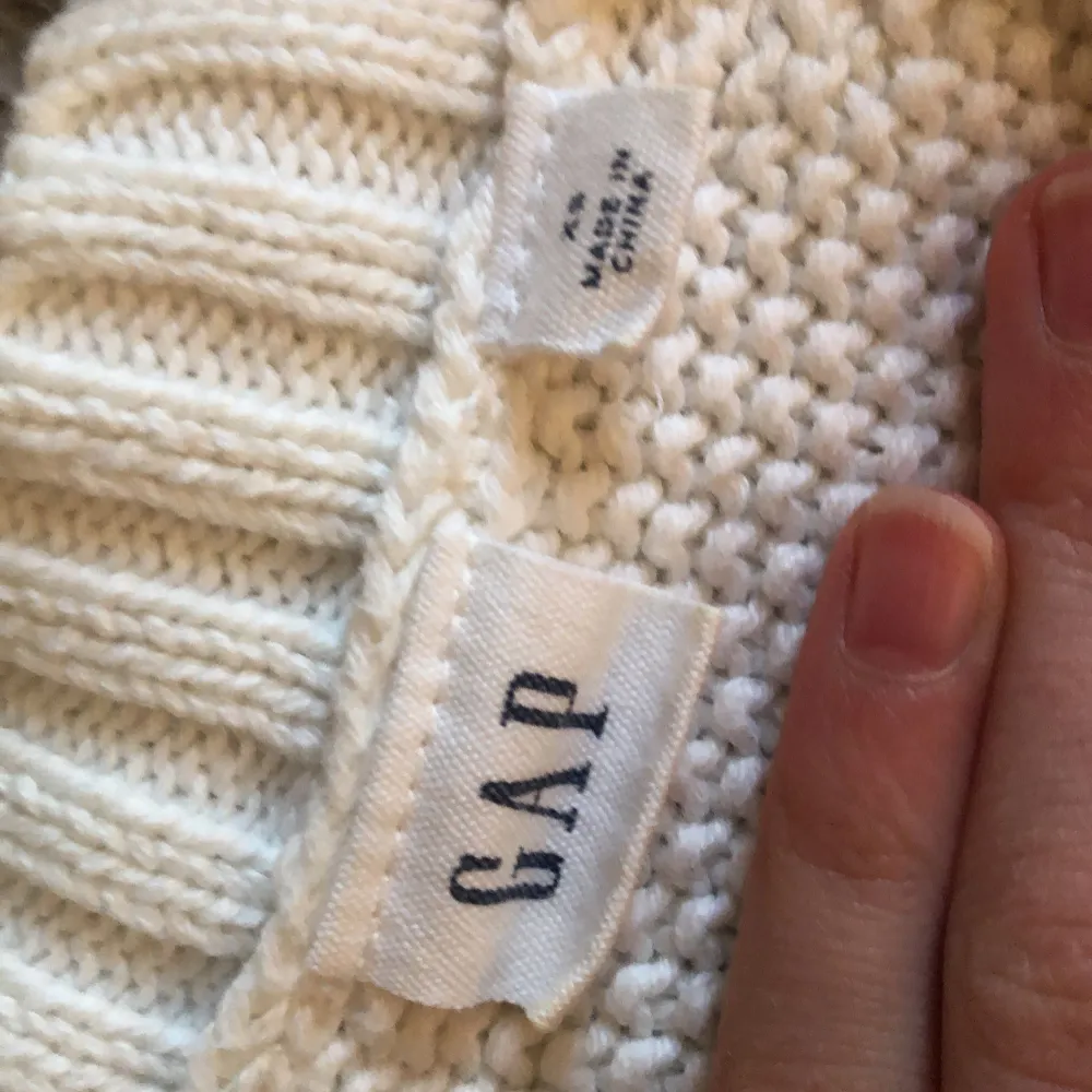 Säljer en stilren vit stickad tröja från GAP med ett snyggt flätmönster. Tröjan har långa ärmar och ribbade kanter vid ärmslut och nederkant. Perfekt för kyliga dagar!. Neuletakit & Villapaidat.