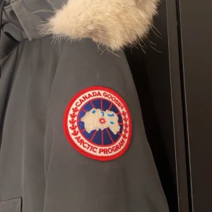 Grå Canada Goose jacka - Säljer en Canada Goose jacka för att jag inte har använt den iår, har använt den förra året men typ bara 2 gånger denna vintern. Det är inga hål eller fläckar.