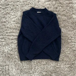 Mörkblå tröja från Gina Tricot - En jättefin stickad tröja från Gina tricot Young. Jag säljer den eftersom jag knappast använder den längre och är lite stickig. På ärmen är det en liten tråd som sticker ut men det ser man knappast.😊💗