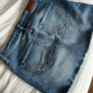 Blå jeanskjol från Hollister - Snygg blå jeanskjol från Hollister med hög midja och slitna detaljer. Jätteeee snyggggg😍😍