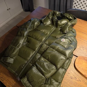 Moncler Maya - Passa på! Moncler Maya i en eftertraktad grön färg. Storlek 2, ny med tags. Fungerande scan. Eventuella frågor? Hör av er.