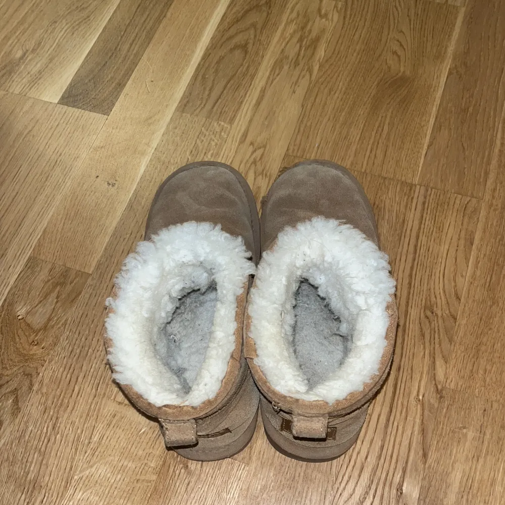 Säljer ett par äkta beige boots från UGG med riktig ull vit pälsfoder. Perfekta för kalla dagar. Lite sliten dock men går att använda och väldigt varma. Pris kan diskuteras. . Kengät.