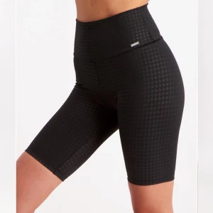 Svarta biker shorts med hundtandsmönster - Snygga svarta biker shorts med ett diskret hundtandsmönster. Perfekta för en aktiv livsstil!