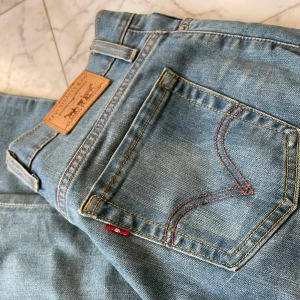 Bootcut jeans från Levis  - Säljer ett par klassiska blå Levis jeans med en bootcut passform. De har den ikoniska Levis-lappen på baksidan och är midwaist. Dem har en liden defekt ned till men är inget som man tänker på. De är lite länge i benen så passar bra för dem som är lite länge eller har ”normal” långa ben. Skriv gjärna vid frågor och inga ytligare bilder finns🩷🩷