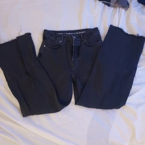 Svarta jeans från Never Denim - Snygga svarta jeans från Never Denim i 100% bomull. De har en fransig kant vid bensluten och klassisk femficksdesign. Perfekta för en avslappnad stil.