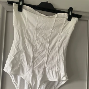 Vit korsett från Bershka - Säljer en snygg vit armlös body från Bershka i storlek M.  