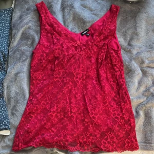 Topp med spets - Nu säljer jag det här jättefina röda linnet med spets på utsidan, jag älskar den men passar inte mig längre så vill ge någon annan chansen att få ha den!
