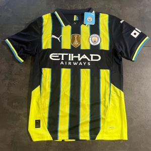 Manchester City Bortaställ 24/25 - Beställde denna för två veckor sedan men var lite för liten för mig. Helt oanvänd och lappen sitter kvar som ni ser. Storlek: M 