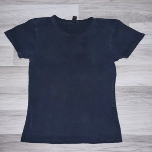 Svart topp från Wol - Säljer en enkel och stilren svart t-shirt från Wol - way of. Den är kortärmad och har en normal passform, perfekt för vardagsbruk. Materialet känns mjukt och bekvämt, vilket gör den till ett bra val för både avslappnade och mer uppklädda tillfällen.